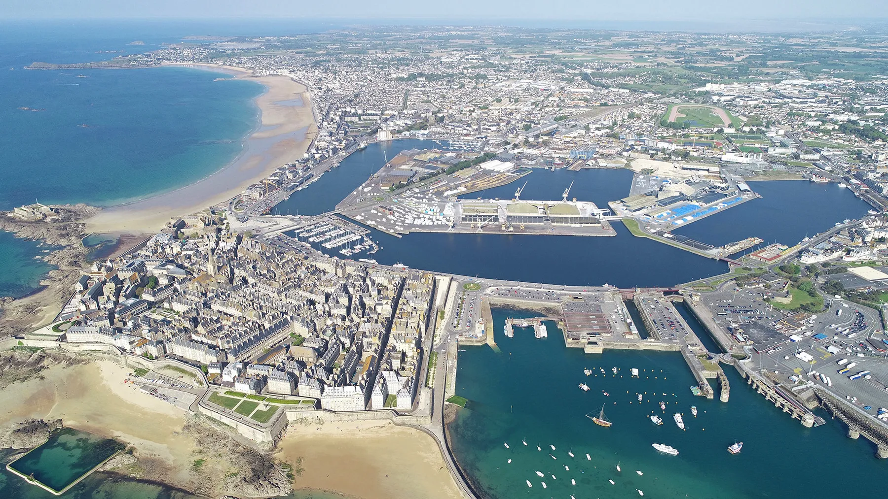 Vue aérienne de Saint-Malo : Intra-Muros, le port, les bassins, et les plages.